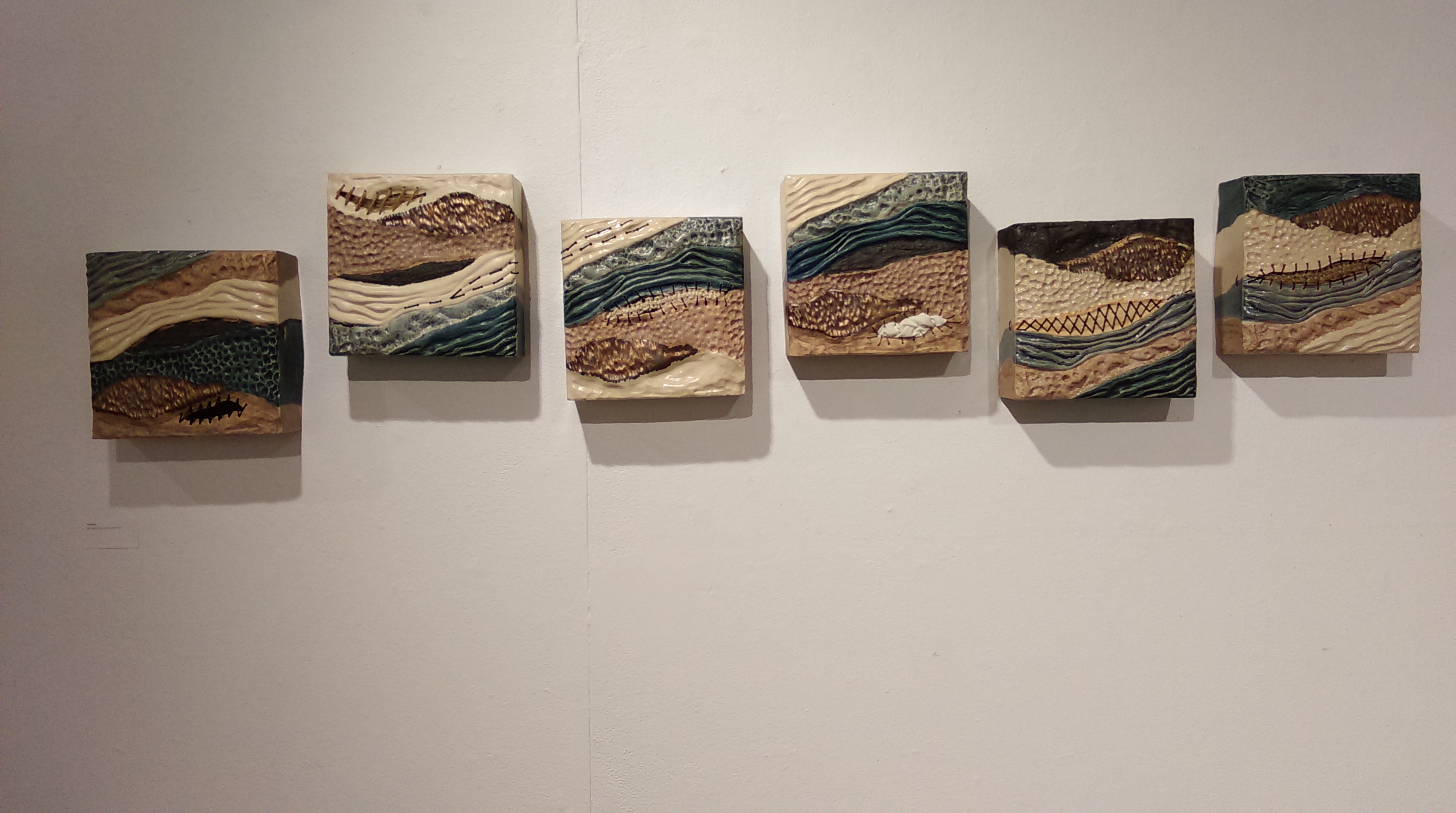 Six ceramic wall tiles depicting layered earth and water landscape